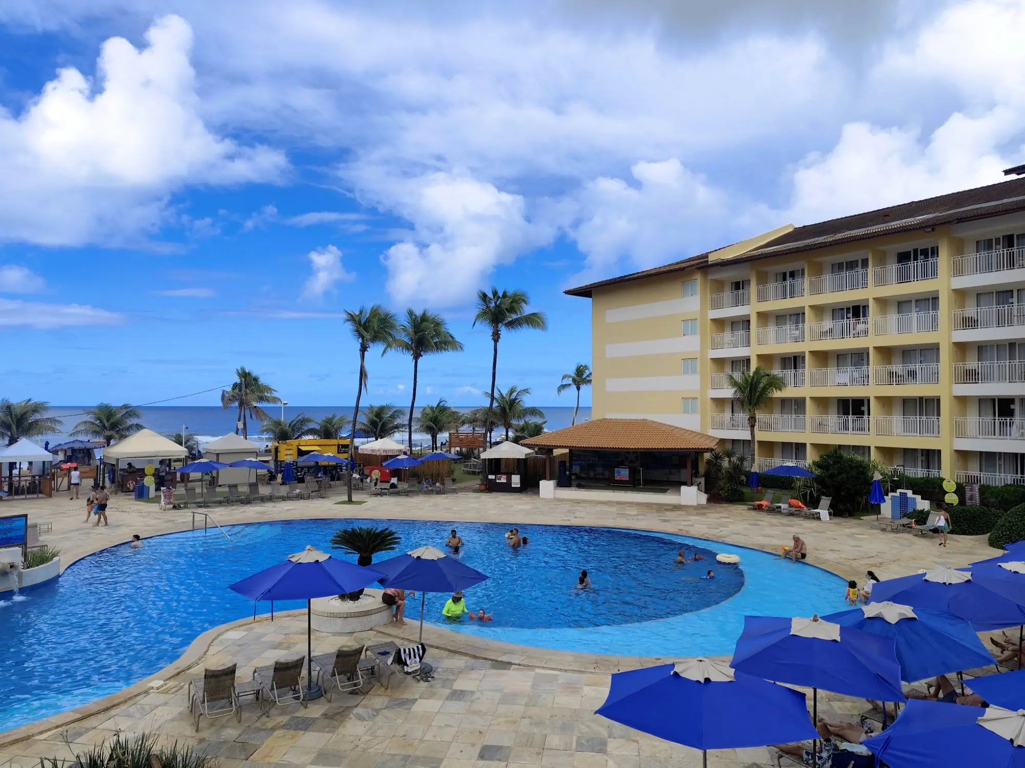 Piscina de resort cercada por coqueiros
